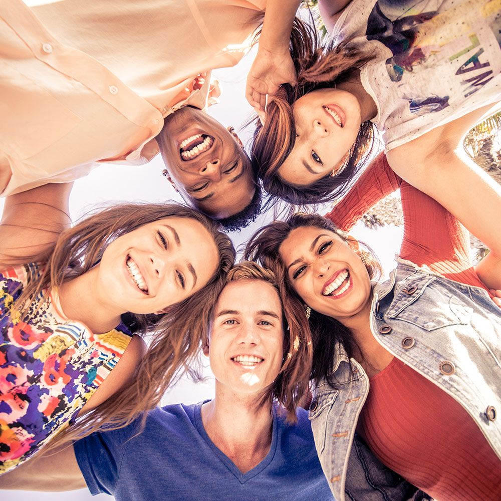 faq-hero group of students huddled together smiling